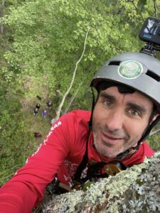 Van Wagner taking a photo of himself in the canopy with his audience on the ground below.